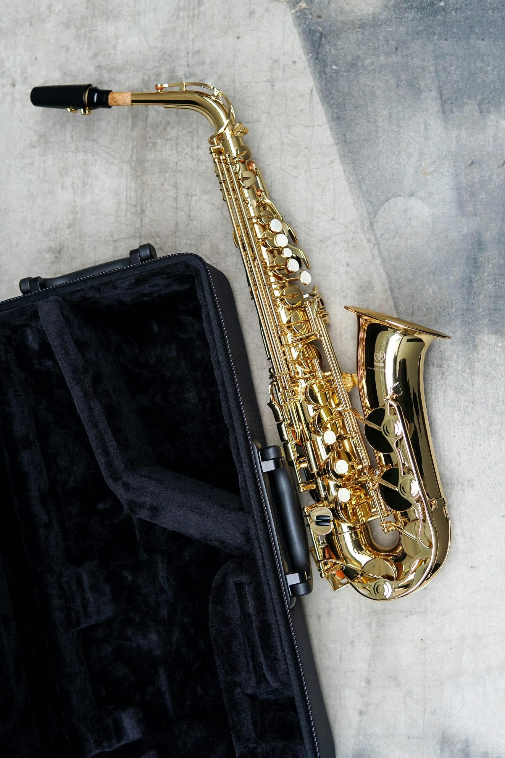 saxophone doré posé à côté de sa sacoche noire